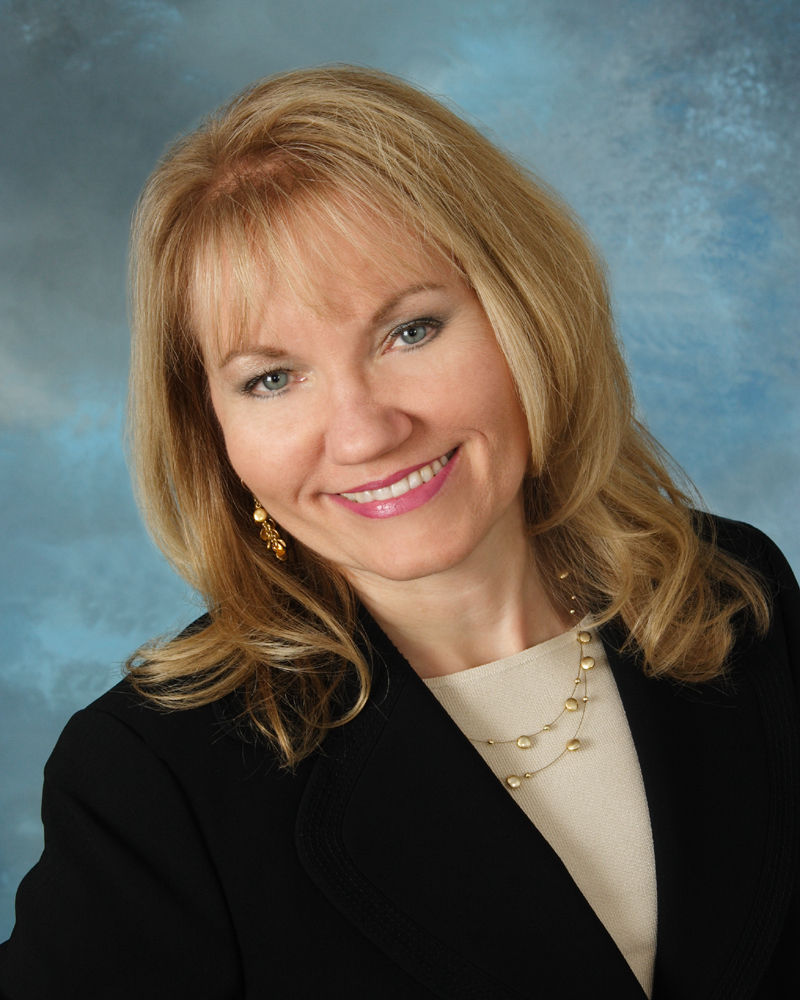 Blonde woman in a white shirt and black blazer