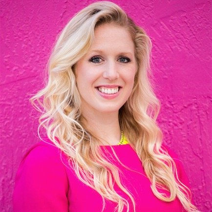 Blonde, white woman smiling in a pink dress