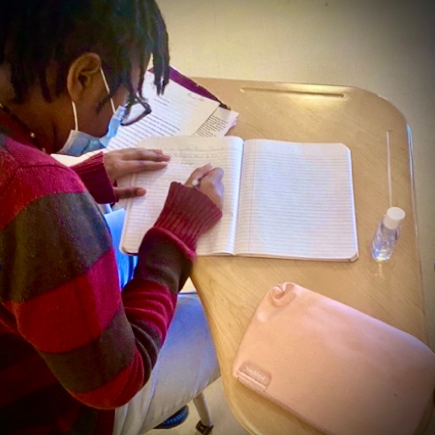 SCPA student writing creatively in their journal