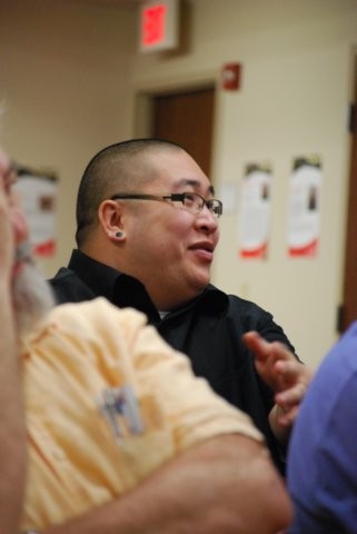 Audience member smiling while listening to speaker