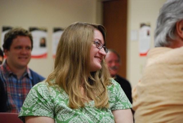 Audience member smiling while listening to speaker
