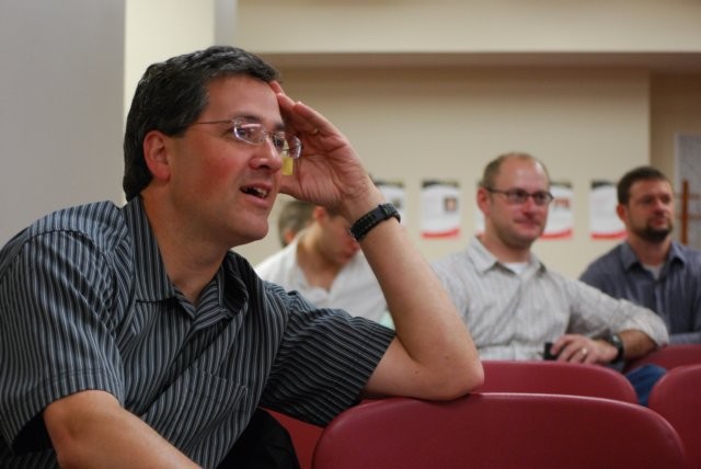 Audience member smiling while listening to speaker