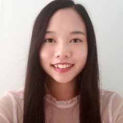 A smiling color photo of Der Vang wearing a pink shirt in front of a white background.