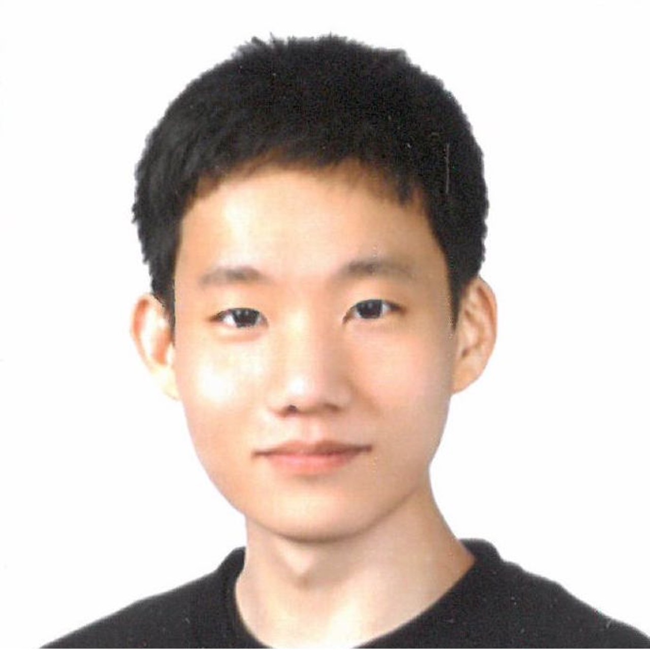 A smiling photo of Juhyeon Park with dark hair, wearing a dark shirt in front of a bright background.