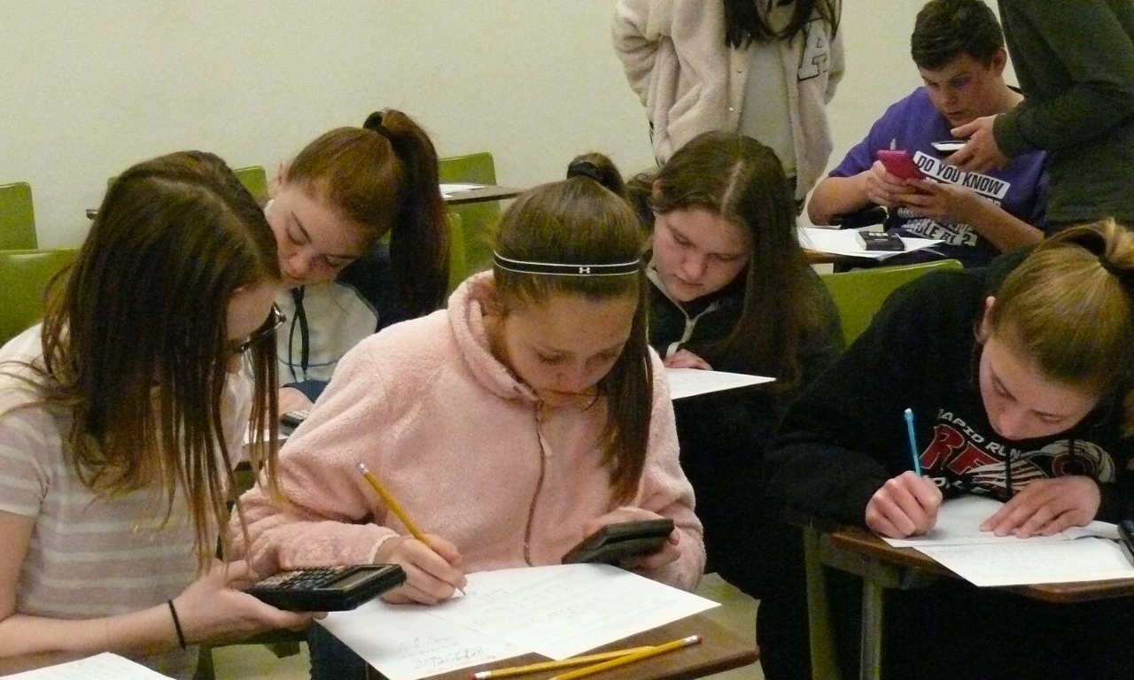 Math Bowl 2018 students working a grouped desks