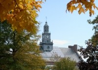 Photo of Mcmicken hall during the fall with brown and red leaves on the trees