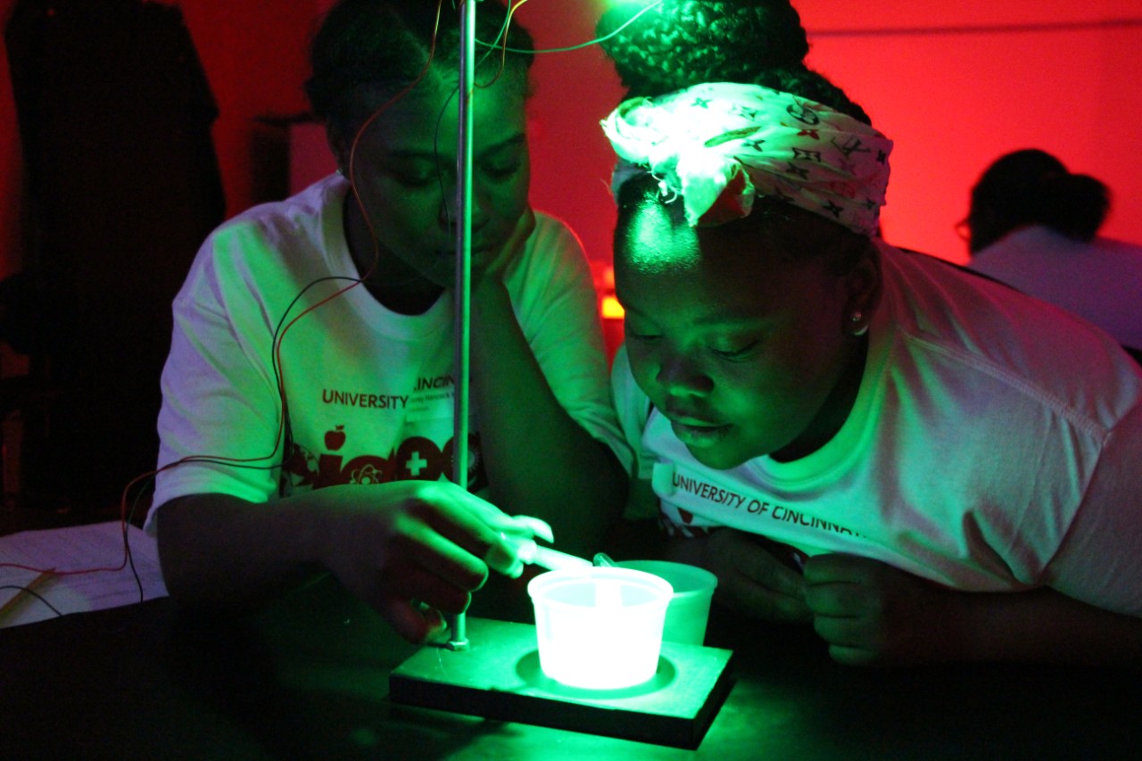 Students huddled around dishes of water beetle larvae to discover which UV light helped the insects hunt the best.