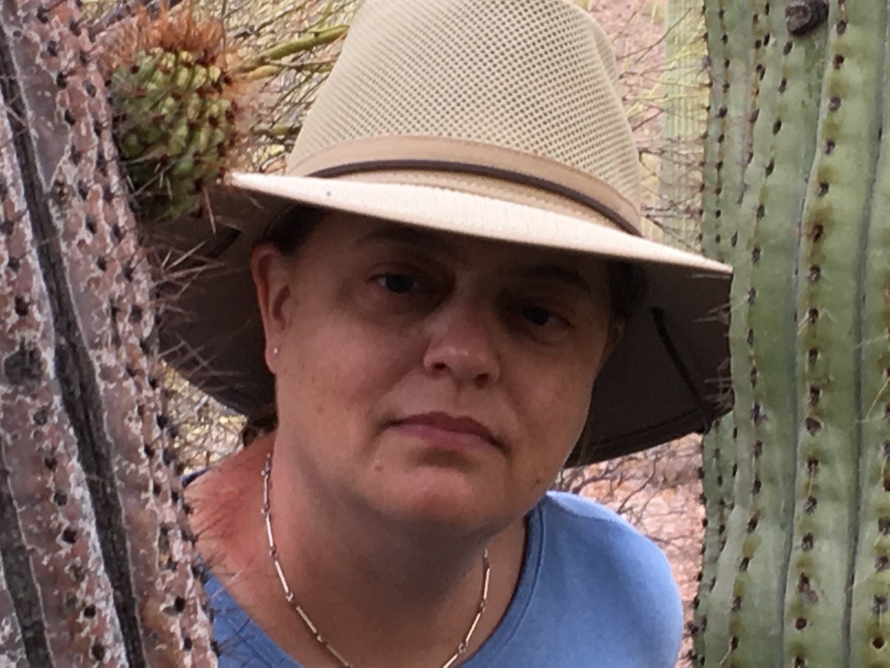 Rollman standing near cactus wearing a hat