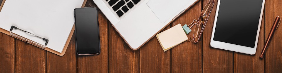 Top View of desk with stationery, coffe and digital product Top View of Modern Technology working Place on wooden Office Desk with large Desktop Computer Coffee Mug Keyboard and Mouse green Flower Notepad and Pen